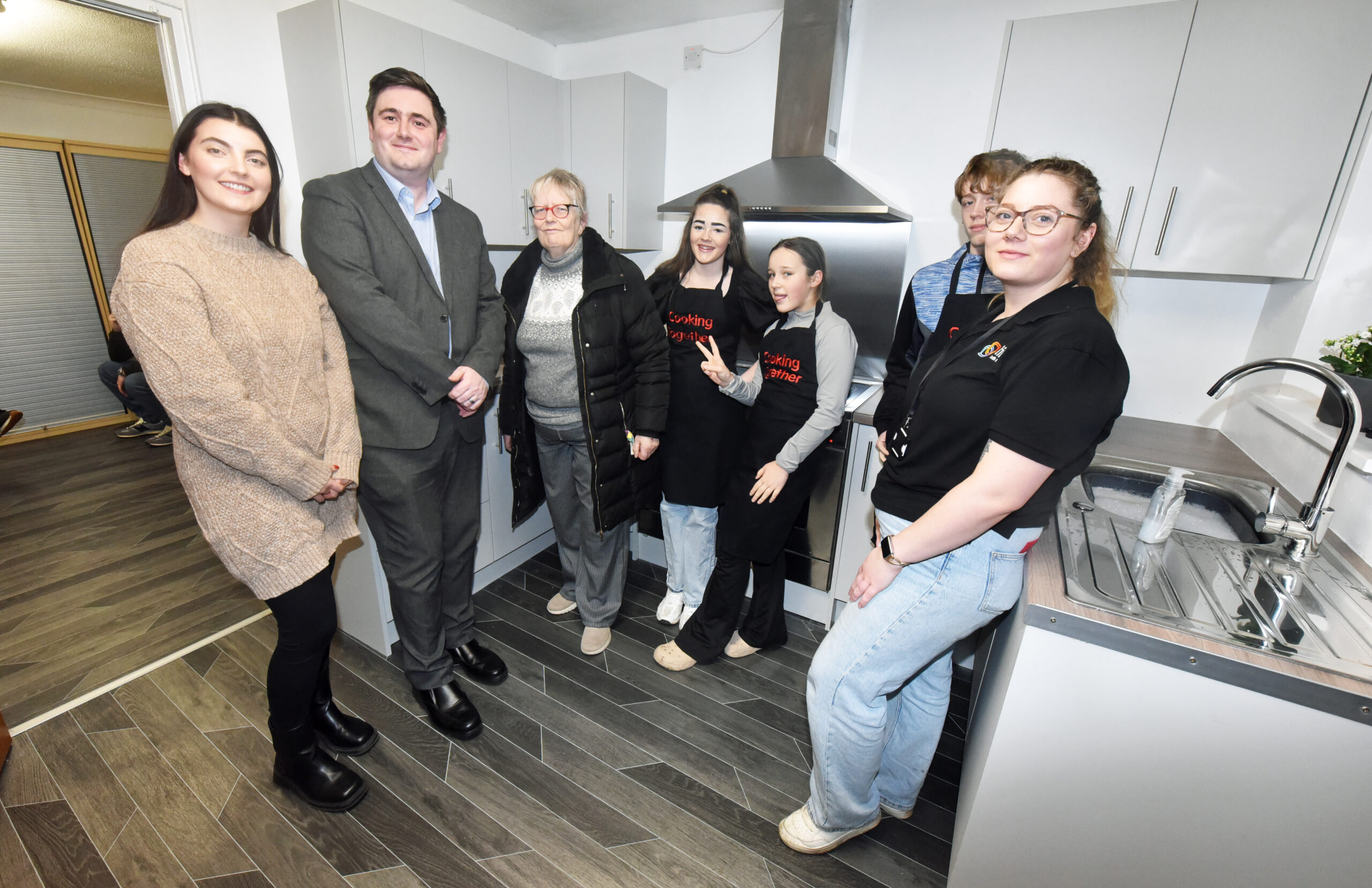 Linx Youth Project team and three young people stand together in the new kitchen.
