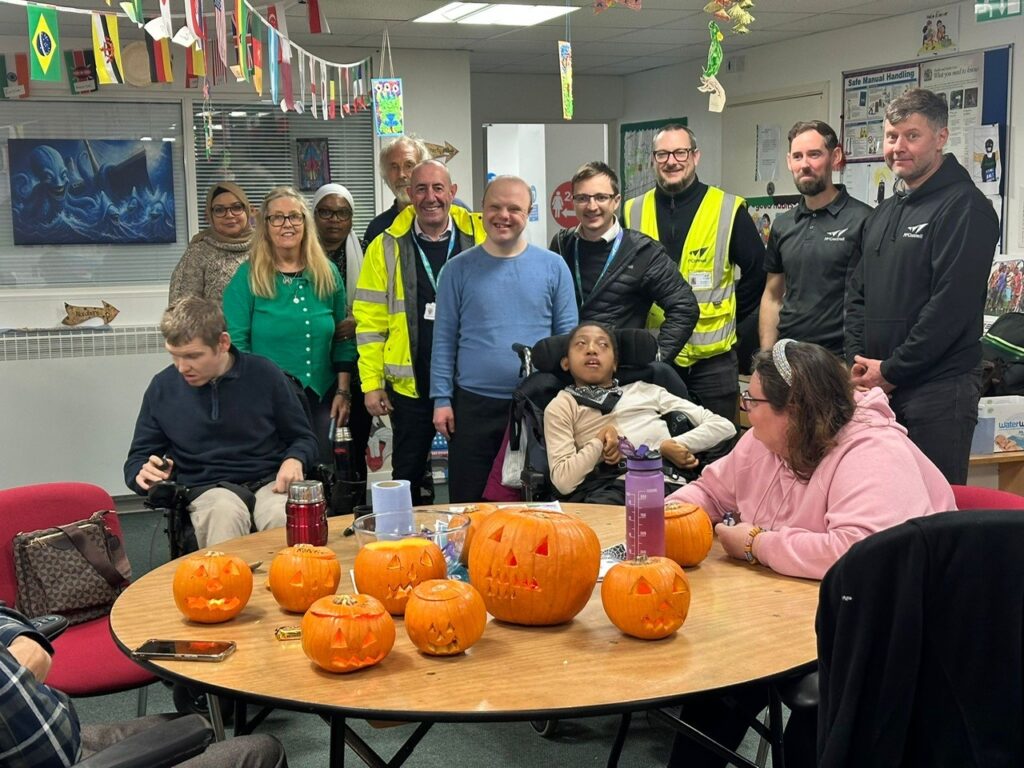 McConnell and Young Brent Foundation staff stand behind a table filled with pumpkins prepared for children’s Halloween festivities.